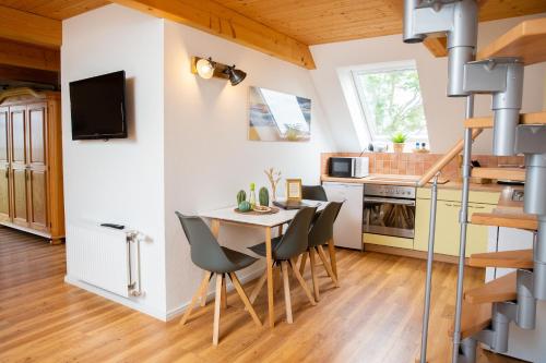 a kitchen and dining room with a table and chairs at Haus im Felde Whg 6 in Fehmarn