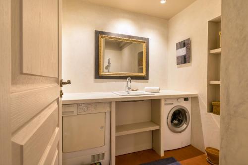 a bathroom with a sink and a washing machine at Le Saint Michel in Dijon