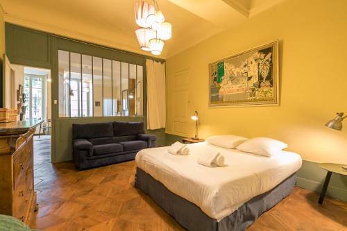 - une chambre avec un grand lit et un canapé dans l'établissement Le Saint Michel, à Dijon