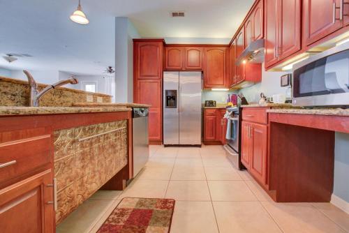 a kitchen with red cabinets and a refrigerator at Gorgeous 1st-Floor, End Unit Condo w LAKEVIEW in Orlando