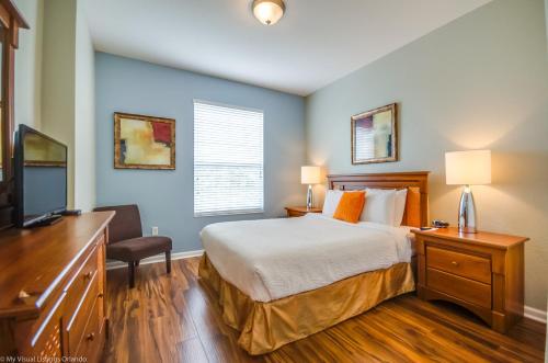 a bedroom with a bed and a desk and a television at Beautiful PET FRIENDLY Condo Near Pool in Orlando