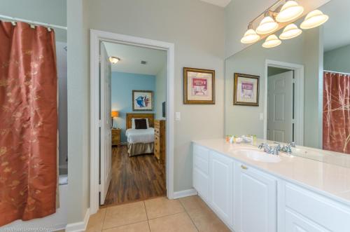 a bathroom with a sink and a mirror at Beautiful PET FRIENDLY Condo Near Pool in Orlando