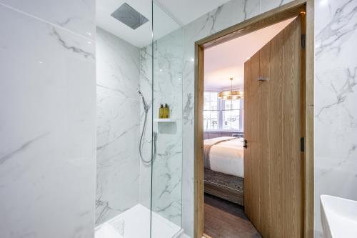 a bathroom with a shower and a glass door at No1 Apartments St Andrews - South Street in St. Andrews