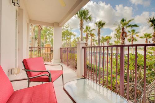 a balcony with red chairs and palm trees at Gorgeous 1st-Floor, End Unit Condo w LAKEVIEW in Orlando