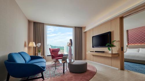 a hotel room with a television and a bed at Amari SPICE Penang in Bayan Lepas