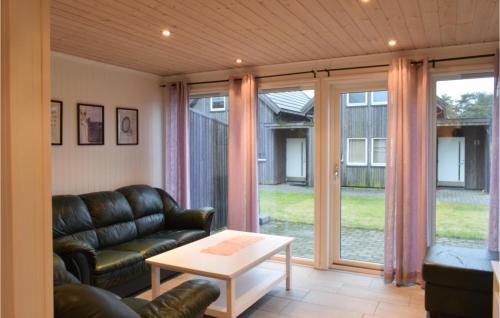 ein Wohnzimmer mit einem Ledersofa und einem Tisch in der Unterkunft Beautiful Home In Sgne With House A Panoramic View in Søgne