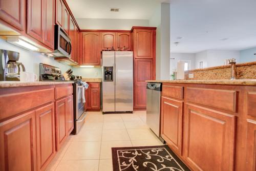 a kitchen with wooden cabinets and a stainless steel refrigerator at Top-Floor Luxurious LAKEVIEW Condo in Orlando