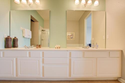 Un baño con dos lavabos y un espejo grande. en Top-Floor Luxurious LAKEVIEW Condo, en Orlando