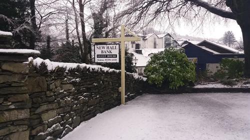 a stone wall with a sign in front of a house at New Hall Bank in Bowness-on-Windermere