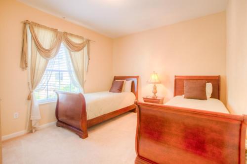 Lovely Third-Floor Vista Cay Resort Condo في أورلاندو: غرفة نوم بسريرين ونافذة