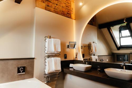 a bathroom with two sinks and a mirror at South Lodge in Lower Beeding