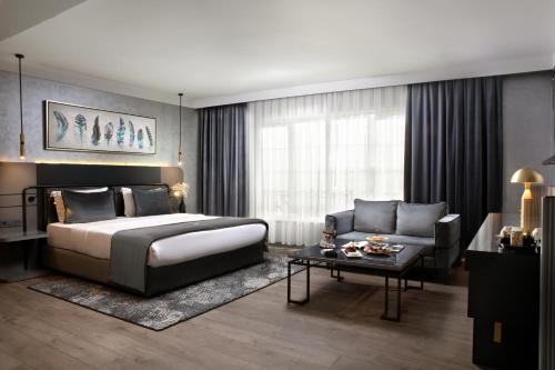 a bedroom with a bed and a couch and a table at The Wings Hotels Neva Palas in Ankara