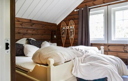 ein Schlafzimmer mit einem Bett mit einer Holzwand in der Unterkunft Lovely Home In Kvinlog With Wifi in Kvinlog