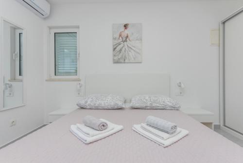 a white room with two towels on a table at Apartments M&A in Makarska