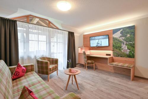 a living room with a couch and a tv at Helmerhof in Schwangau