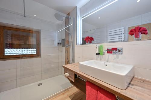 a white bathroom with a sink and a shower at Helmerhof in Schwangau