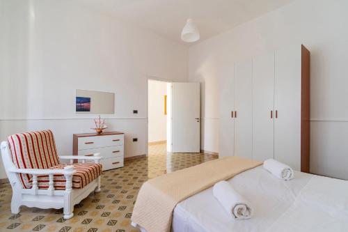 トッレ・スーダにあるVilla Marcella by BarbarHouseの白いベッドルーム(ベッド1台、椅子付)