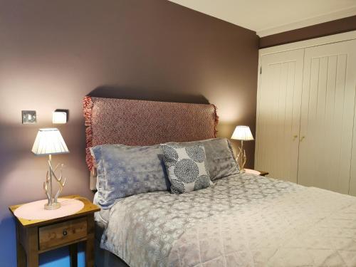 een slaapkamer met een bed met kussens en 2 lampen bij Award Winning 2023 luxury Holiday Rental Apartment Stratford London in Londen