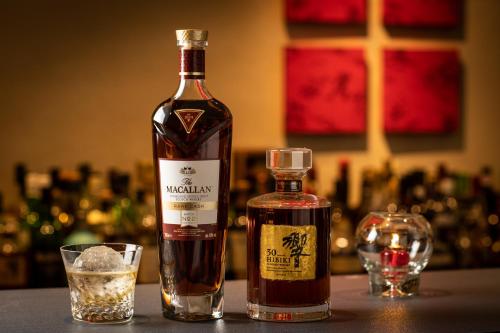 a bottle of whisky next to a glass at Villa Sanjomuromachi KYOTO in Kyoto