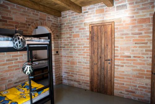 a room with a brick wall and a wooden door at Ecitlav - ubytování Valtice in Valtice