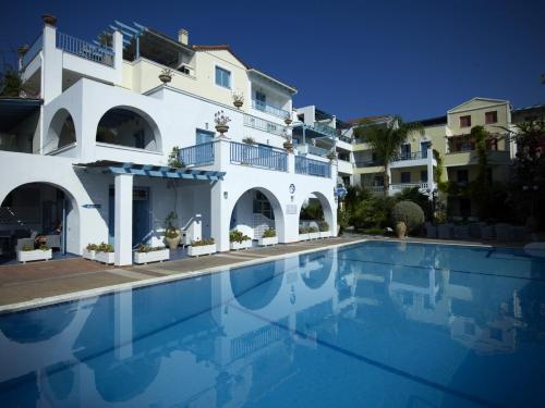 a large swimming pool in front of a white building at Nikis Village in Poros