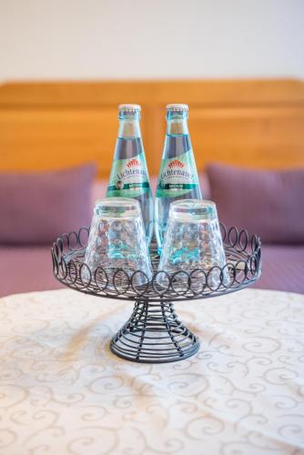 three bottles and three glasses on a tray on a table at Bilz-Pension in Radebeul