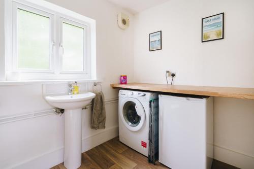 a bathroom with a washing machine and a sink at Quay Quarters in Chichester