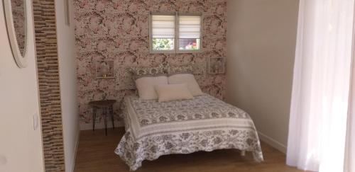 a small bedroom with a bed and a window at Le pin bleu in Pérassay