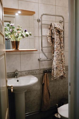 a bathroom with a sink and a vase of flowers at Hoby Kulle Herrgård B&B in Bräkne-Hoby