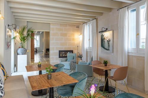 a restaurant with tables and chairs and a fireplace at Hotel Boutique Can Sastre in Ciutadella