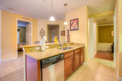 La cuisine est équipée d'un évier et d'un lave-vaisselle. dans l'établissement Stylish Condo at Vista Cay Resort Minutes to WDW, à Orlando