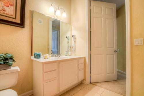 a bathroom with a sink and a mirror at Stylish Condo at Vista Cay Resort Minutes to WDW in Orlando