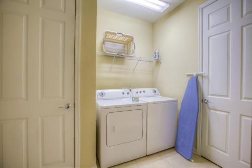 a laundry room with a washing machine and a door at Stylish Condo at Vista Cay Resort Minutes to WDW in Orlando