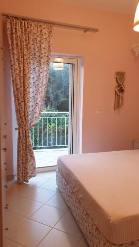 a bedroom with a bed and a large window at Pogonia Panorama Apartment in Paleros