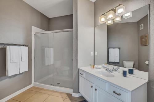 a white bathroom with a shower and a sink at Newly Updated Condo w Scenic Resort View in Orlando