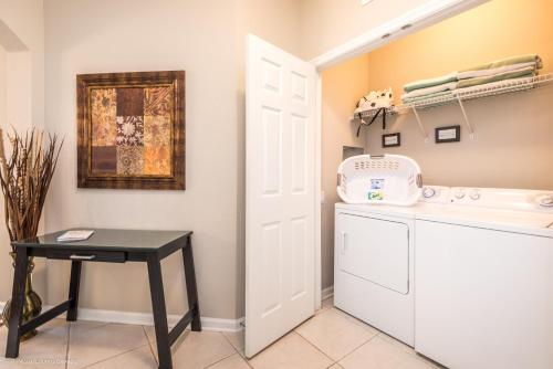 eine Waschküche mit einem Waschbecken und einem Tisch in der Unterkunft Stylish Vista Cay Condo, near Orlando attractions in Orlando