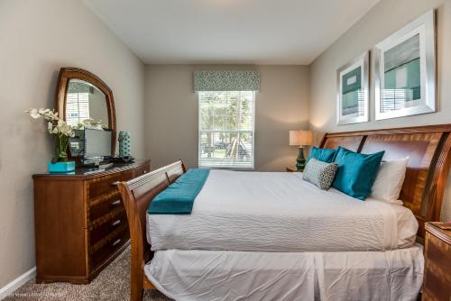 Schlafzimmer mit einem Bett, einer Kommode und einem Spiegel in der Unterkunft Stylish Vista Cay Condo, near Orlando attractions in Orlando