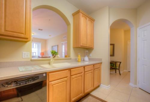 - une cuisine avec des placards en bois et un comptoir dans l'établissement Lovely Vista Cay Resort Condo, Near ClubhousePool, à Orlando