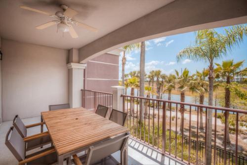a dining room with a table and a balcony with palm trees at Beautiful LAKEVIEW Deluxe Condo Near Theme Parks in Orlando