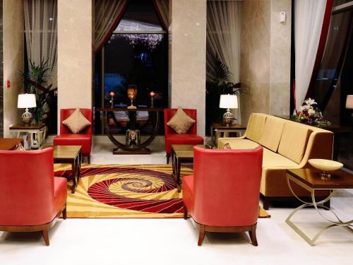 a living room filled with tables and chairs at Landmark Premier Hotel in Dubai