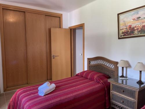 a small bedroom with a bed with a red blanket at Apartamentos Santa Teresinha in Alvor