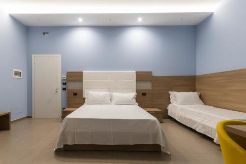 a bedroom with two beds and a blue wall at Al Duomo B&B in Amantea