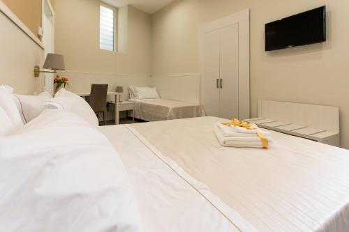 a bedroom with two white beds and a television at Al Duomo B&B in Amantea