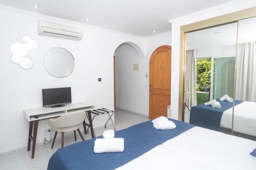 een slaapkamer met 2 bedden en een bureau met een computer bij NURA Apartments - Condor in Palma de Mallorca
