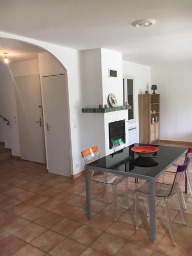 une salle à manger avec une table et des chaises et une cheminée dans l'établissement Aquamarine, un lieu zen au coeur de Vaison la Romaine, à Vaison-la-Romaine