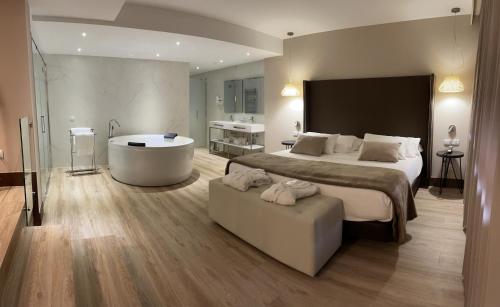 a bedroom with a large bed and a bath tub at Hotel Maria Cristina in Toledo