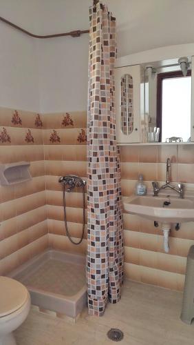 a bathroom with a tub and a sink and a toilet at Hellmann Apartments in Afionas