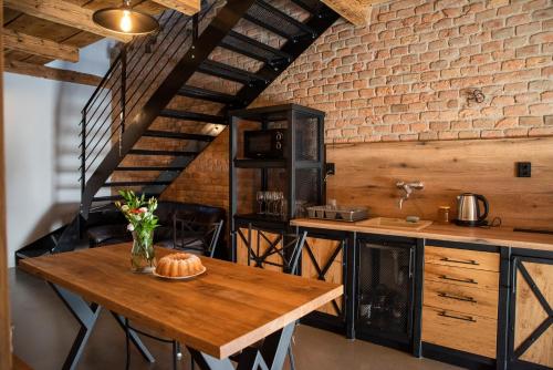 a kitchen with a wooden table and a brick wall at Ecitlav - ubytování Valtice in Valtice