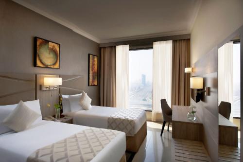 a hotel room with two beds and a window at Two Seasons Hotel & Apartments in Dubai