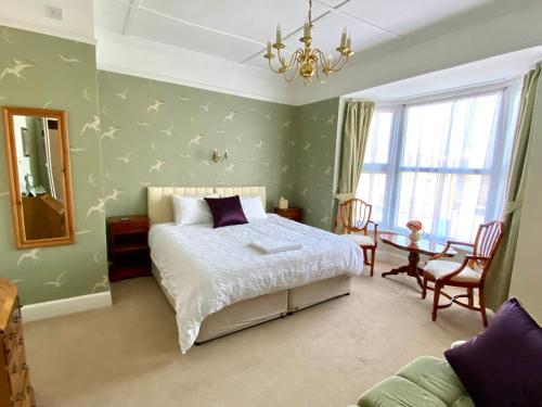 um quarto com uma cama, uma mesa e um espelho em St. Georges House em Shanklin